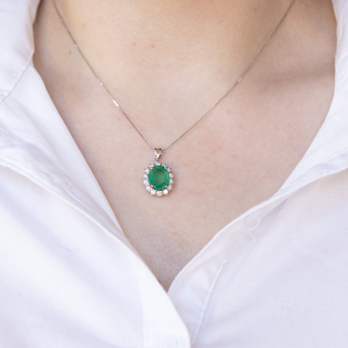 18kt white gold necklace with oval emerald and diamond outline