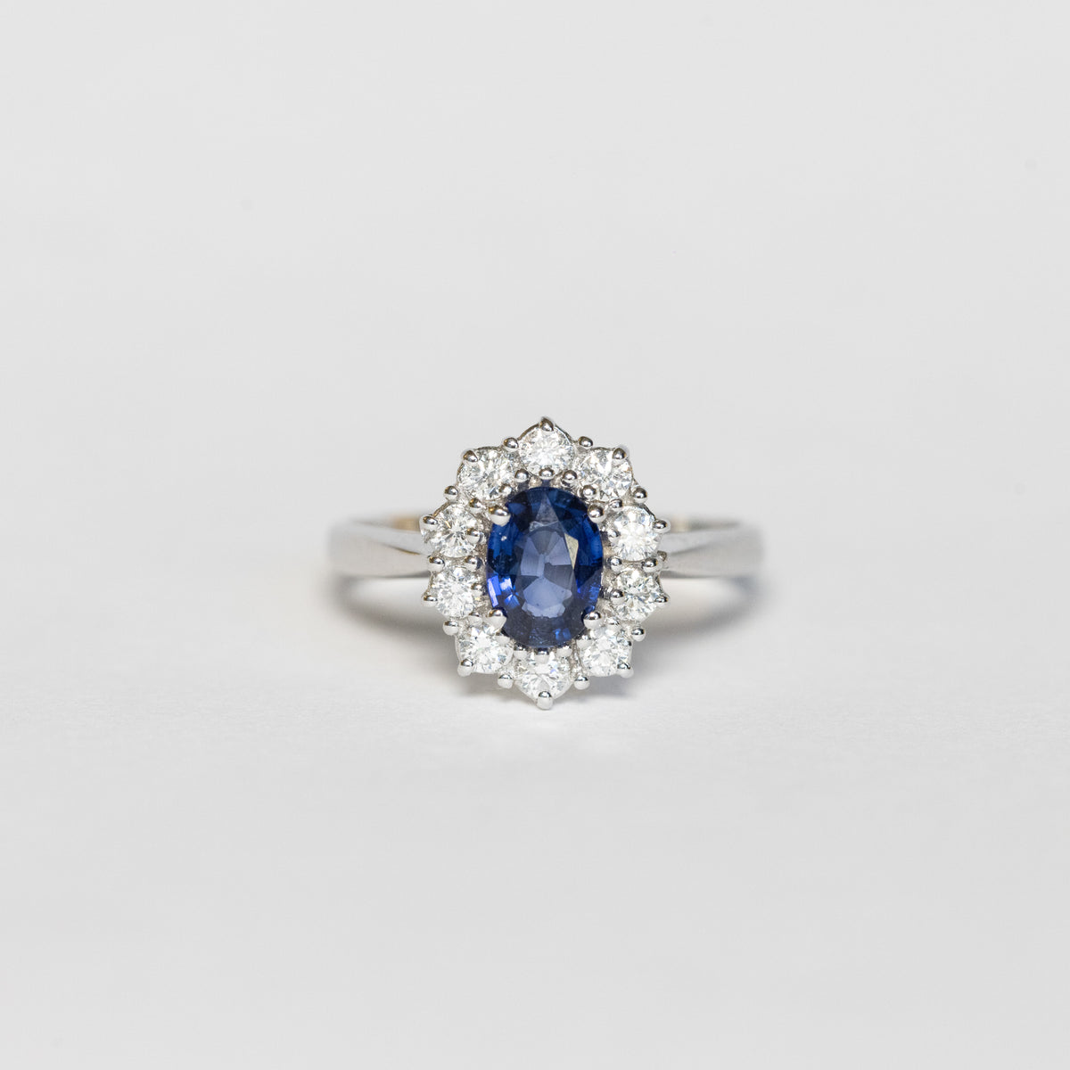 18kt white gold ring with sapphire and diamond surround