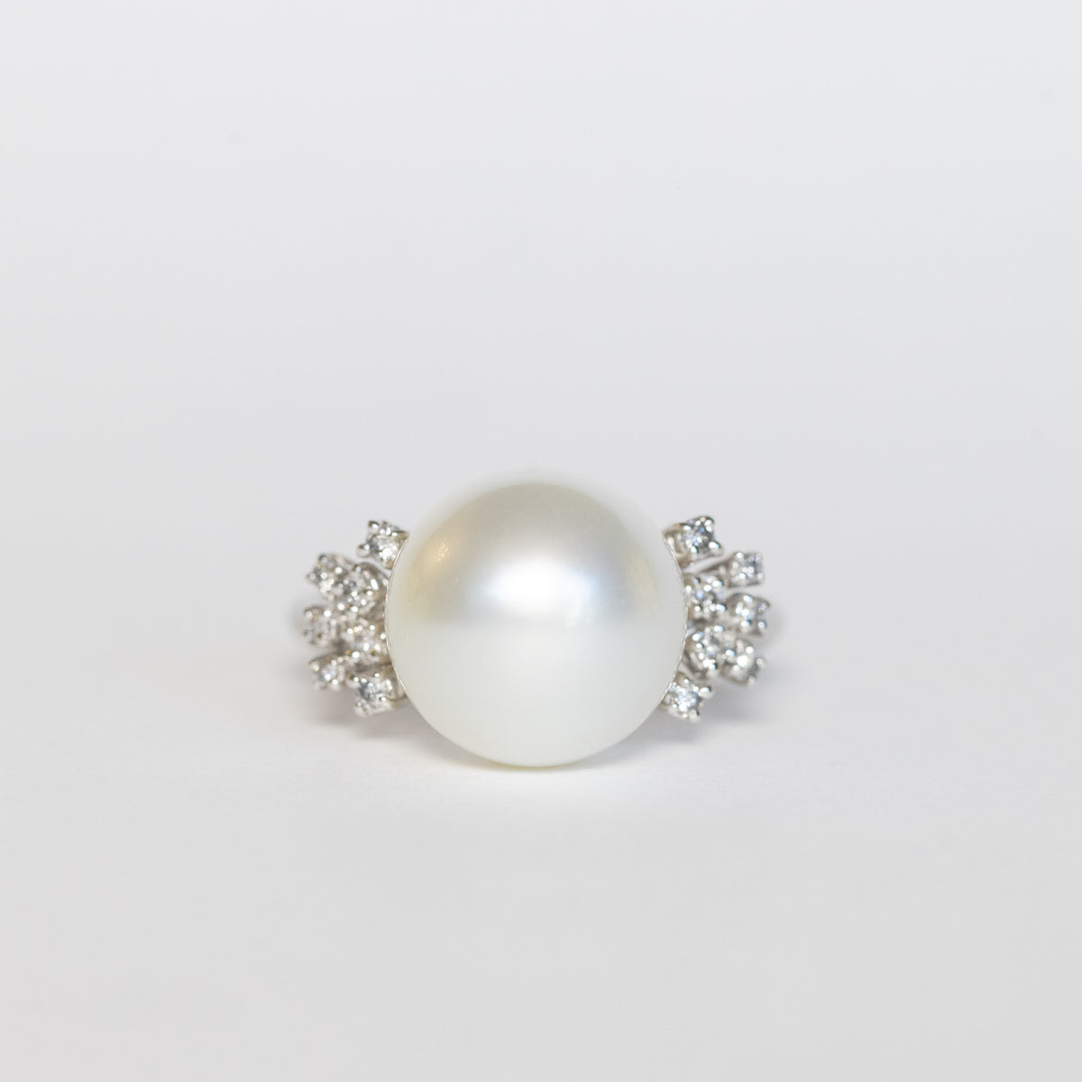 18KT white gold ring with central pearl and lateral diamonds
