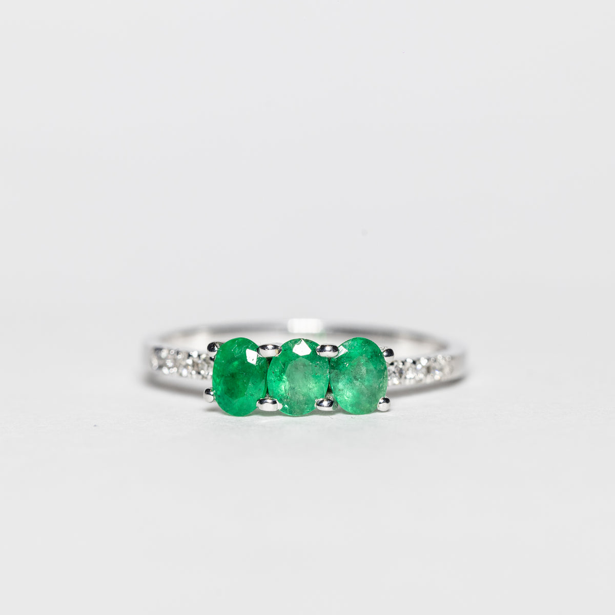 18KT White Gold Trilogy Ring with Emeralds and Diamonds on the Setting