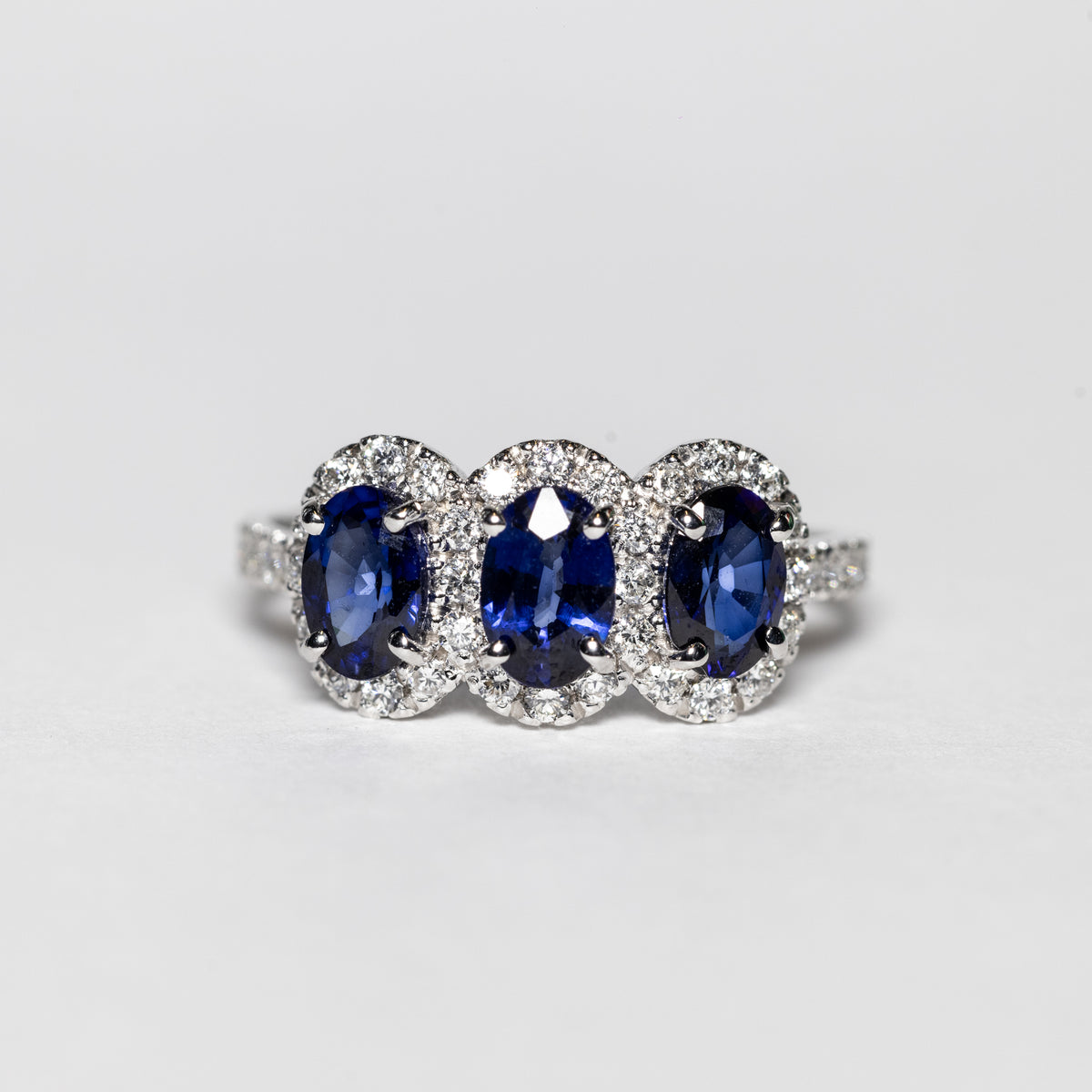 Anello Trilogy in Oro Bianco 18 KT con Zaffiri e Giro di Diamanti