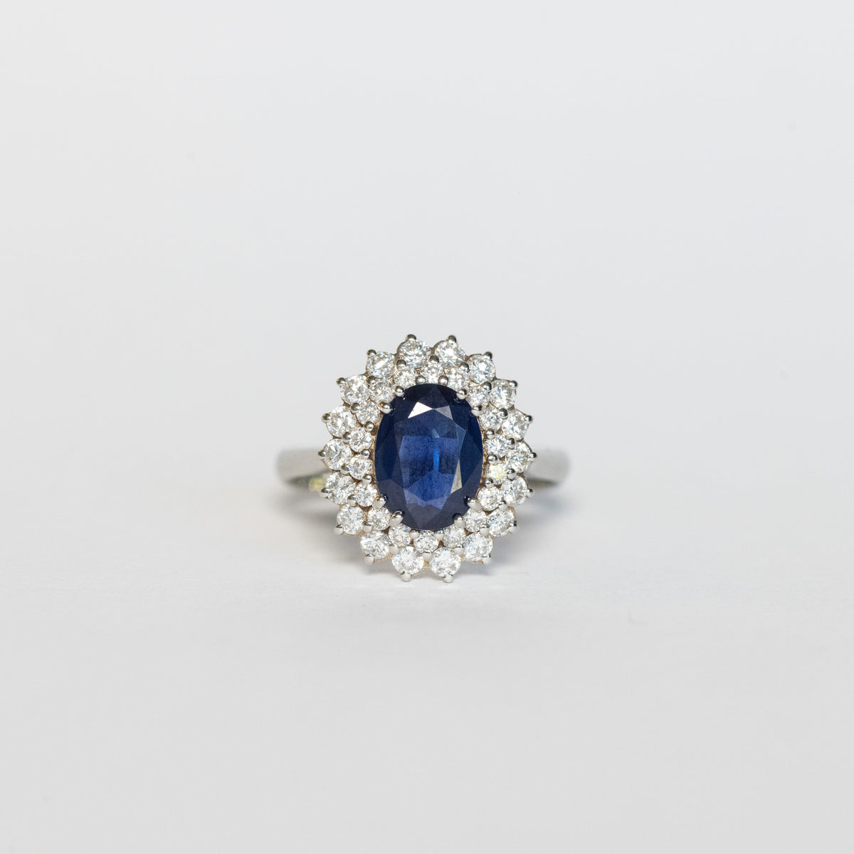 Anello in Oro Bianco 18 kt con Zaffiro Centrale e doppio giro di Diamanti