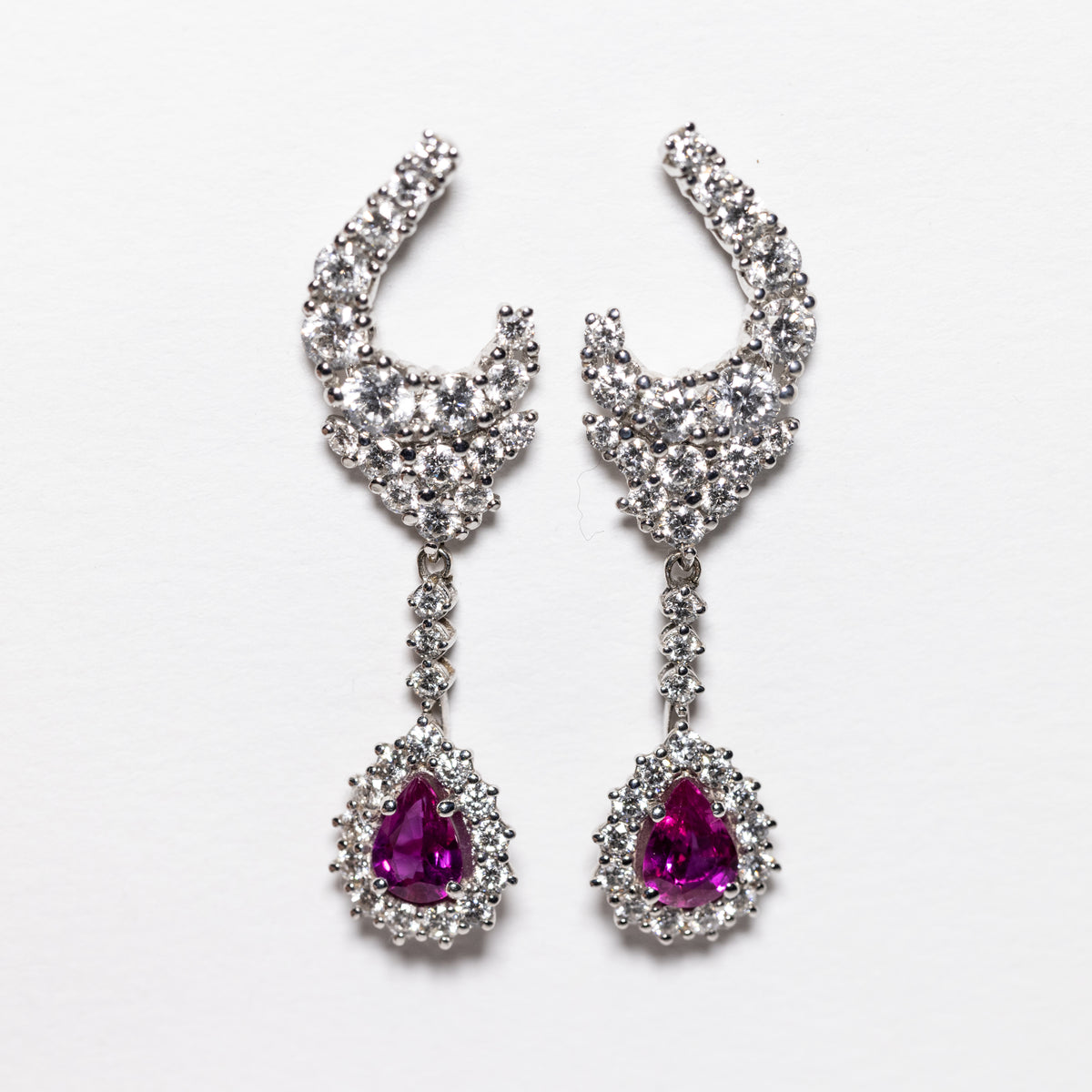 18kt white gold earrings with drop-shaped rubies surrounded by diamonds