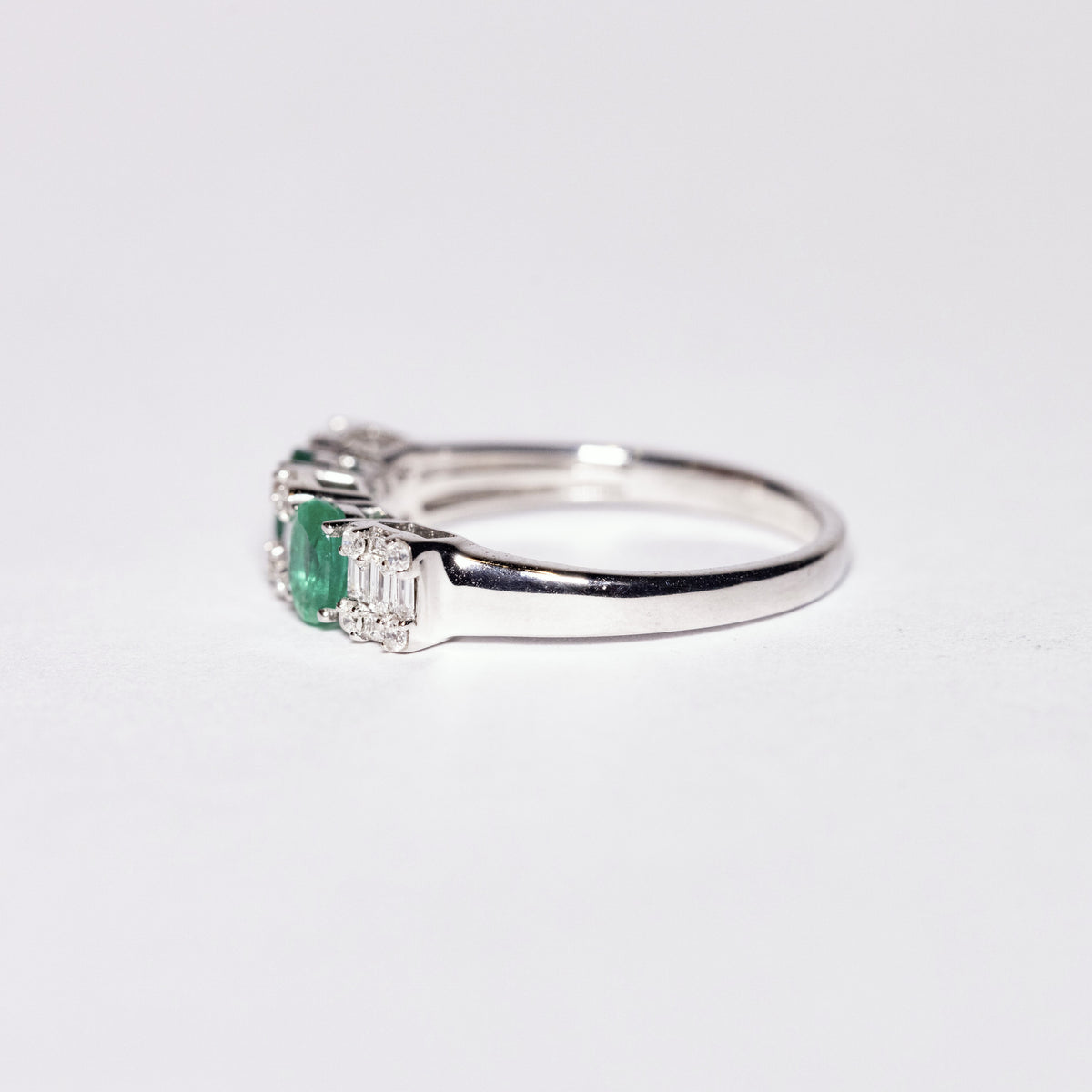 18kt White Gold Ring with Oval Cut Emeralds and Baguette Cut Diamonds