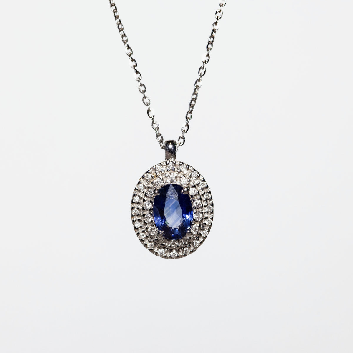 18kt White Gold Necklace with Oval Cut Sapphire with Double Diamond Contour