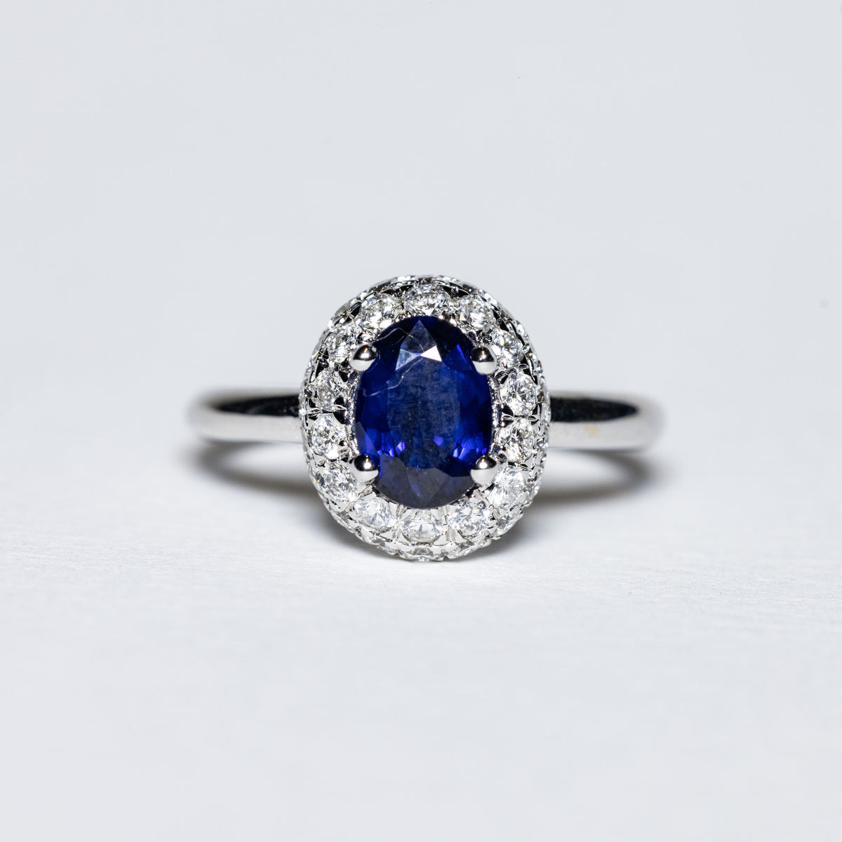 Anello in Oro Bianco 18 KT con Zaffiro Centrale e Doppio Giro di Diamanti