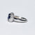 Anello in Oro Bianco 18 KT con Zaffiro Centrale e Doppio Giro di Diamanti