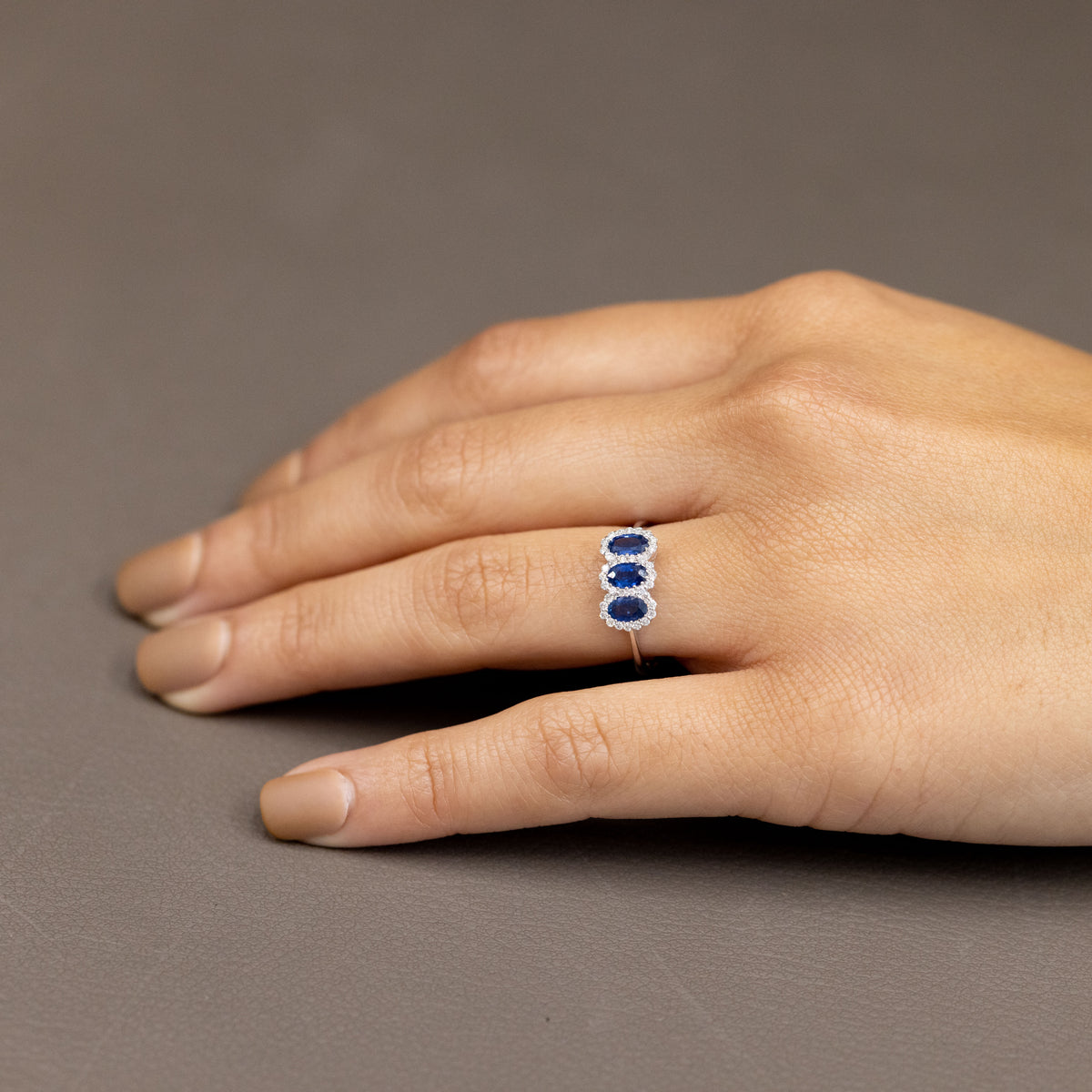 18Kt White Gold Trilogy Ring With Sapphires Surrounded By Diamonds