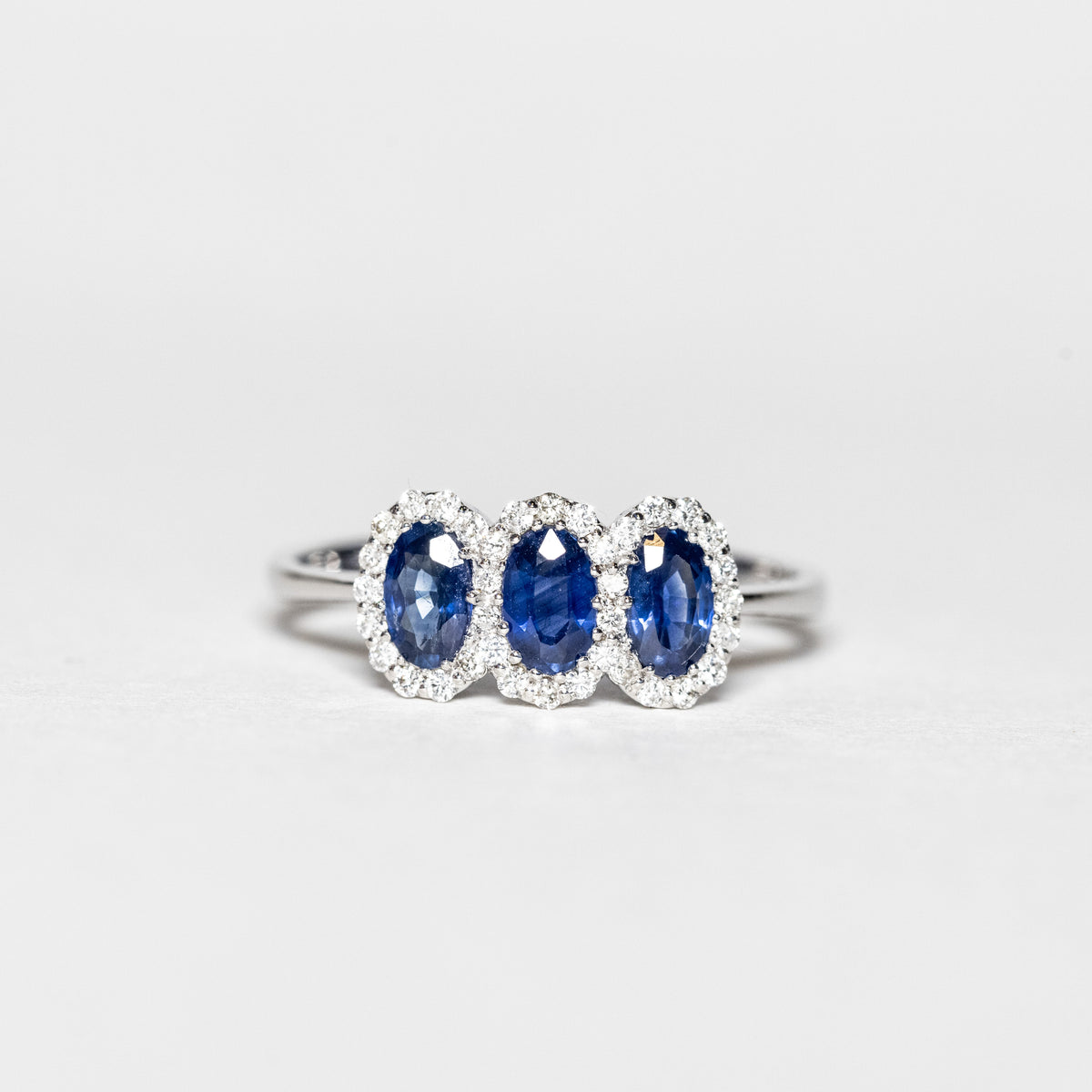 18Kt White Gold Trilogy Ring With Sapphires Surrounded By Diamonds