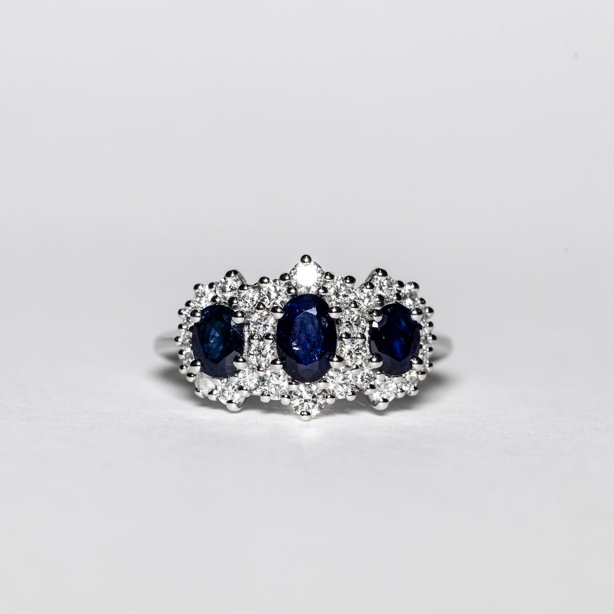 Anello Trilogy in Oro Bianco 18 Kt con Zaffiri Contornati di Diamanti