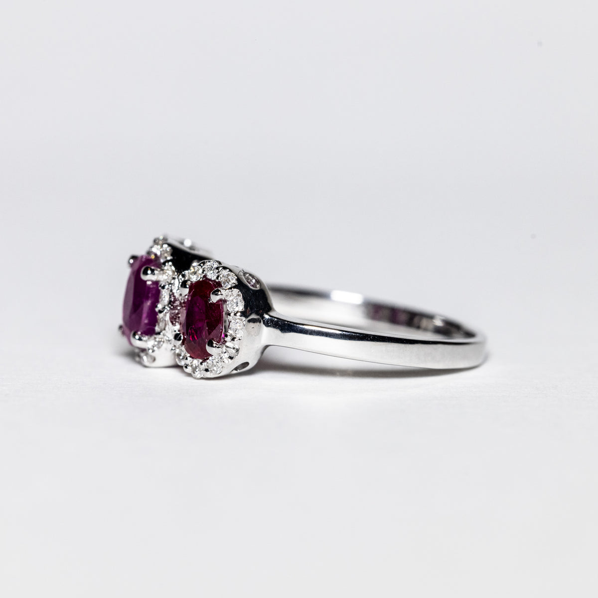 Anello in Oro Bianco 18 Kt con Rubini Laterali Color Rosso e Rubino Centrale Color Rosato Contornati di Diamanti