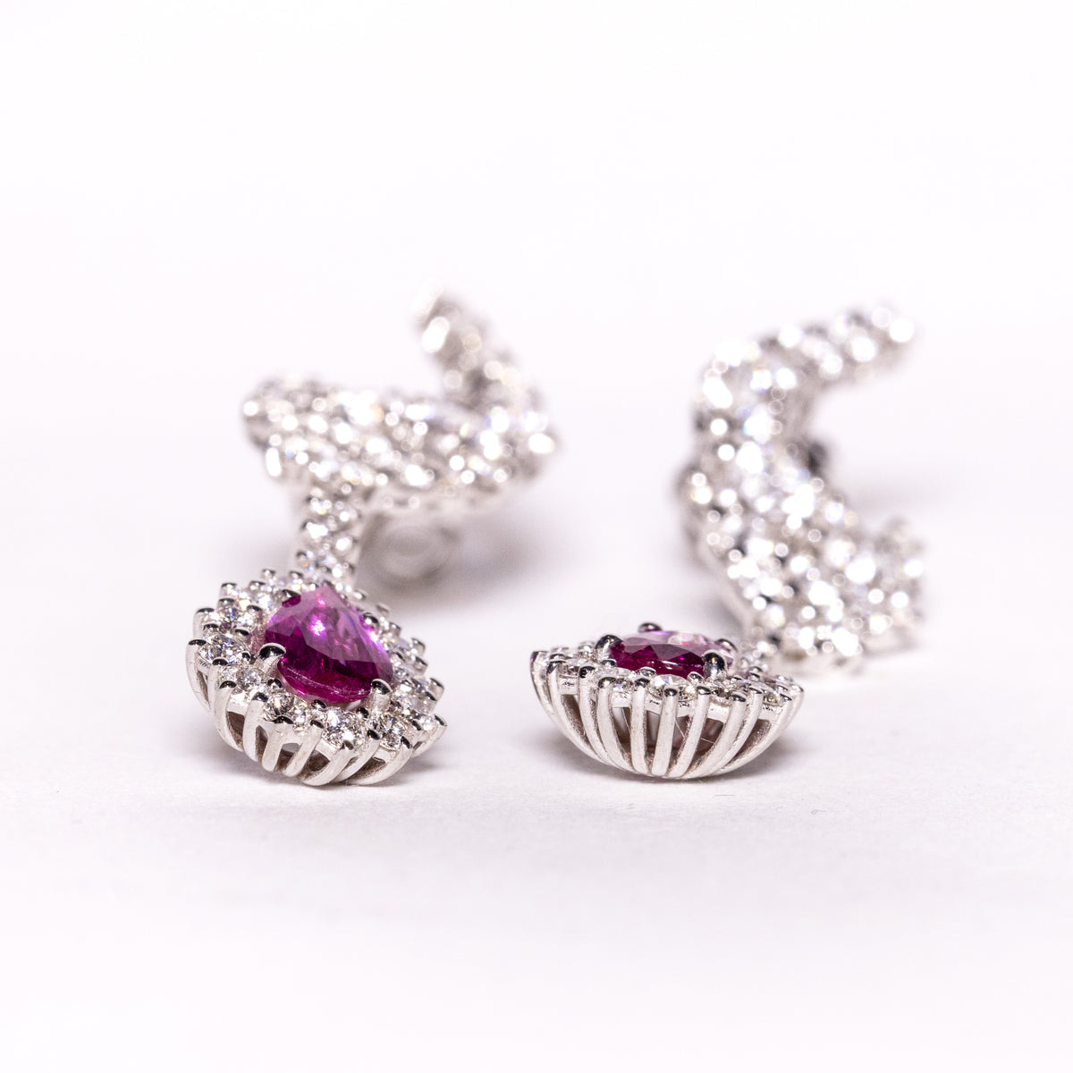 18kt white gold earrings with drop-shaped rubies surrounded by diamonds