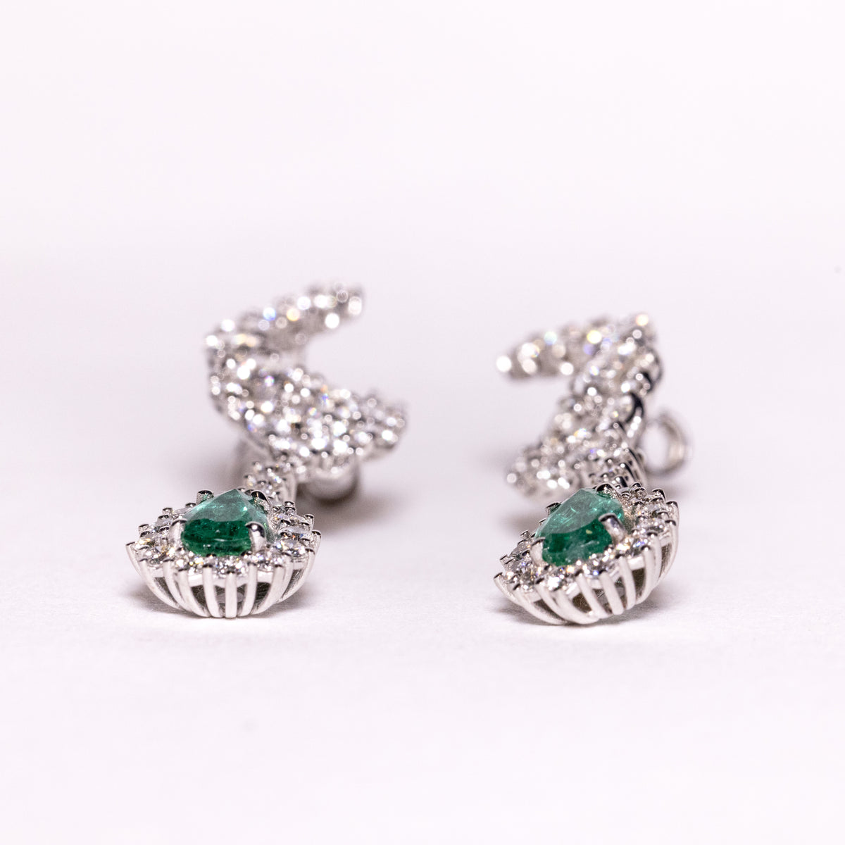 18kt white gold earrings with drop-shaped emeralds surrounded by diamonds