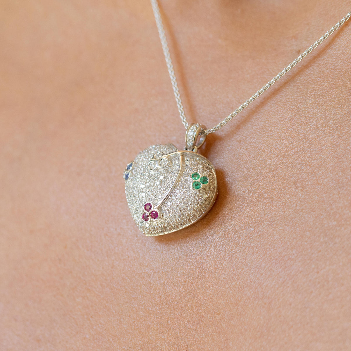 18kt white gold heart-shaped pendant necklace in pavé diamonds and cluster patterns of emeralds, sapphires, rubies and diamonds