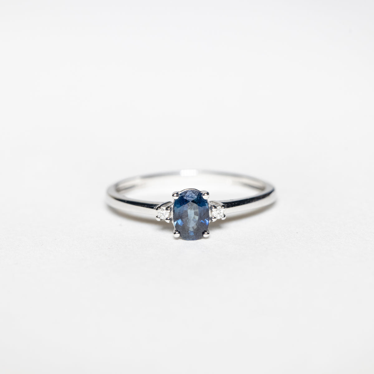 Anello in oro bianco 18kt con zaffiro ovale centrale e diamanti laterali